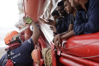 Un volontaire de l'Ocean Viking salue un groupe de migrants (archives).